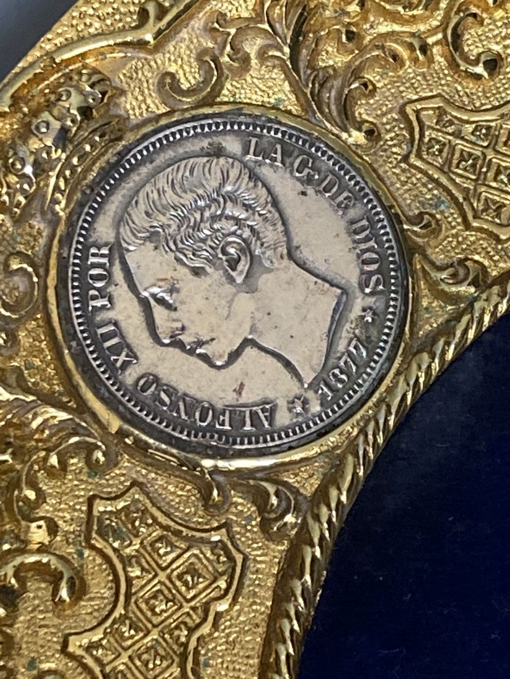 A gilt commemorative plate inset with three Spanish silver 5 Pesetas coins, 1871, 1877, 1885